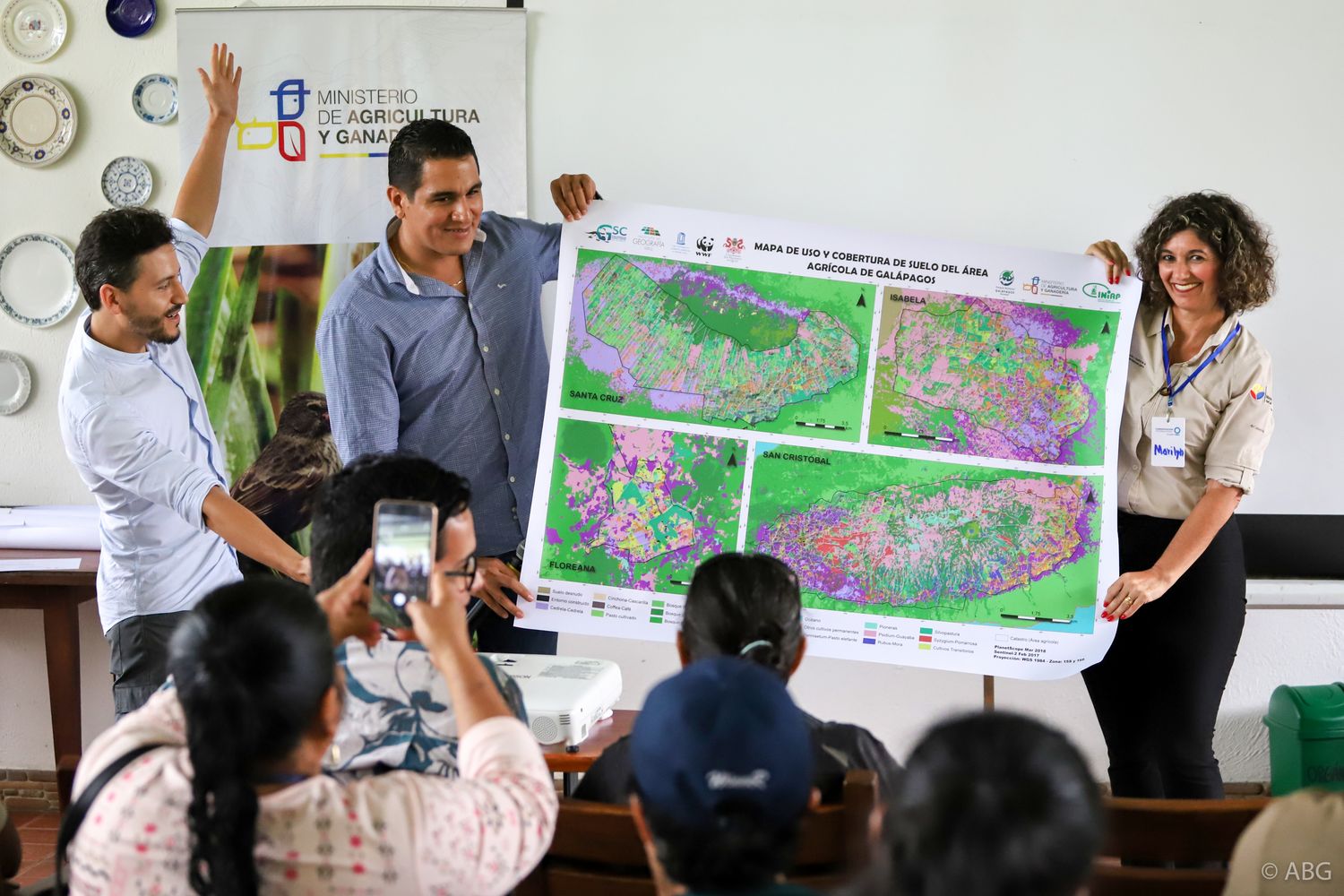 Francisco Laso and colleagues presenting a large land-cover map to an audience in the Galápagos